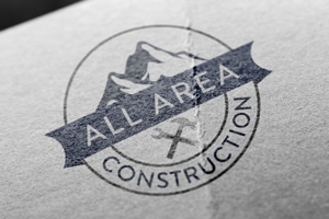 All Area Construction logo mockup with mountain badge design on textured paper